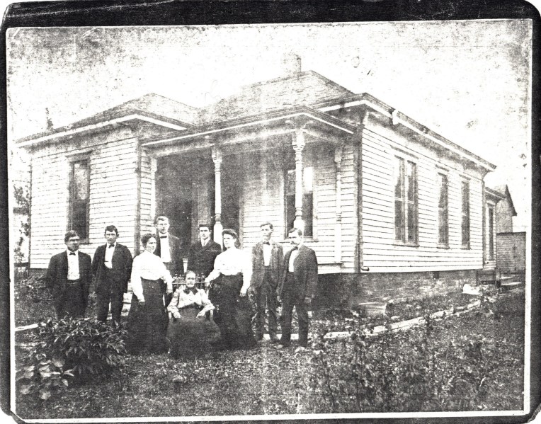 Photocopy of old photo, family standing before house